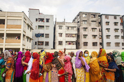 People wait for relief aid in Dhaka, Bangladesh, amid the coronavirus pandemic, disregarding social distance guidelines.