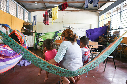 A woman and her children seek refuge in a temporary makeshift shelter in Honduras in November 2020 after hurricanes devastated the region.