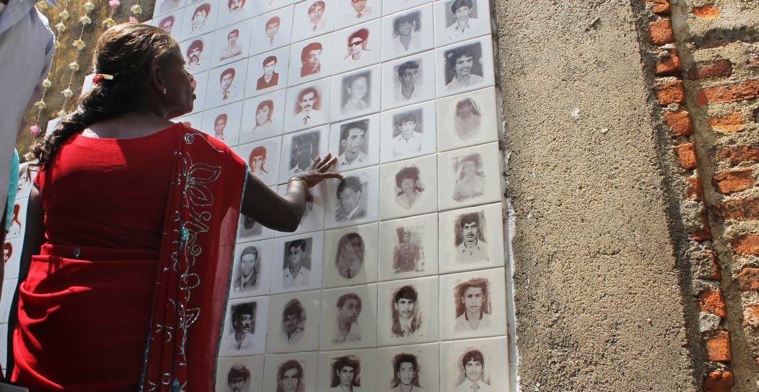 Image of a woman paying tribute at a memorial to the disappeared in Raddoluwa, Sri Lanka.