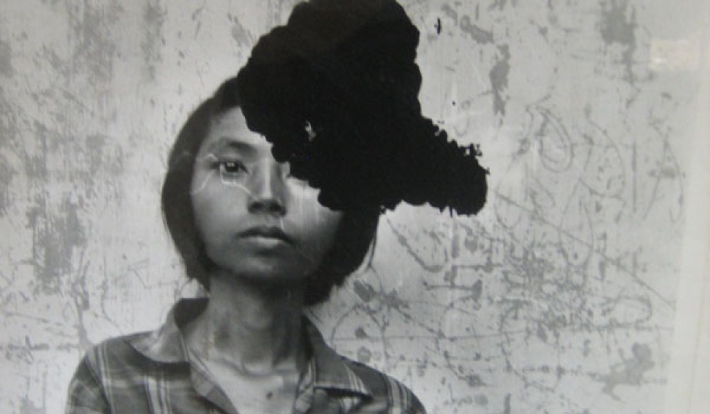 A damaged black and white photo of a Cambodian woman.