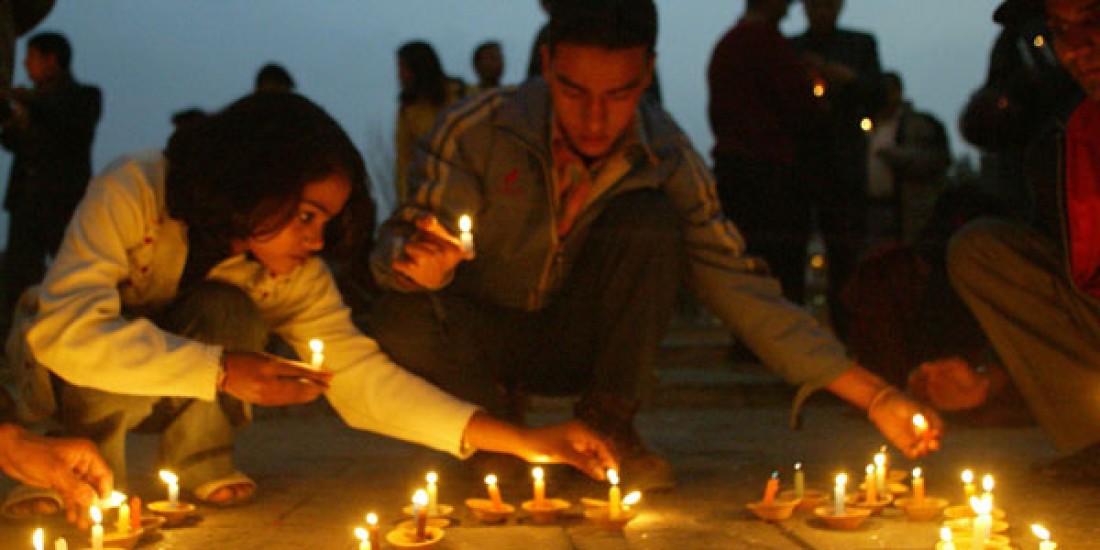 Image des jeunes Népalais qui allument des bougies en mémoire des victimes du conflit. 