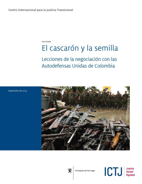 cover a report featuring a photo in which there is a pile of military rifles in the foreground and a group of paramilitary soldiers in the background.