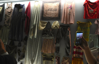 Articles of clothing hang inside a display case