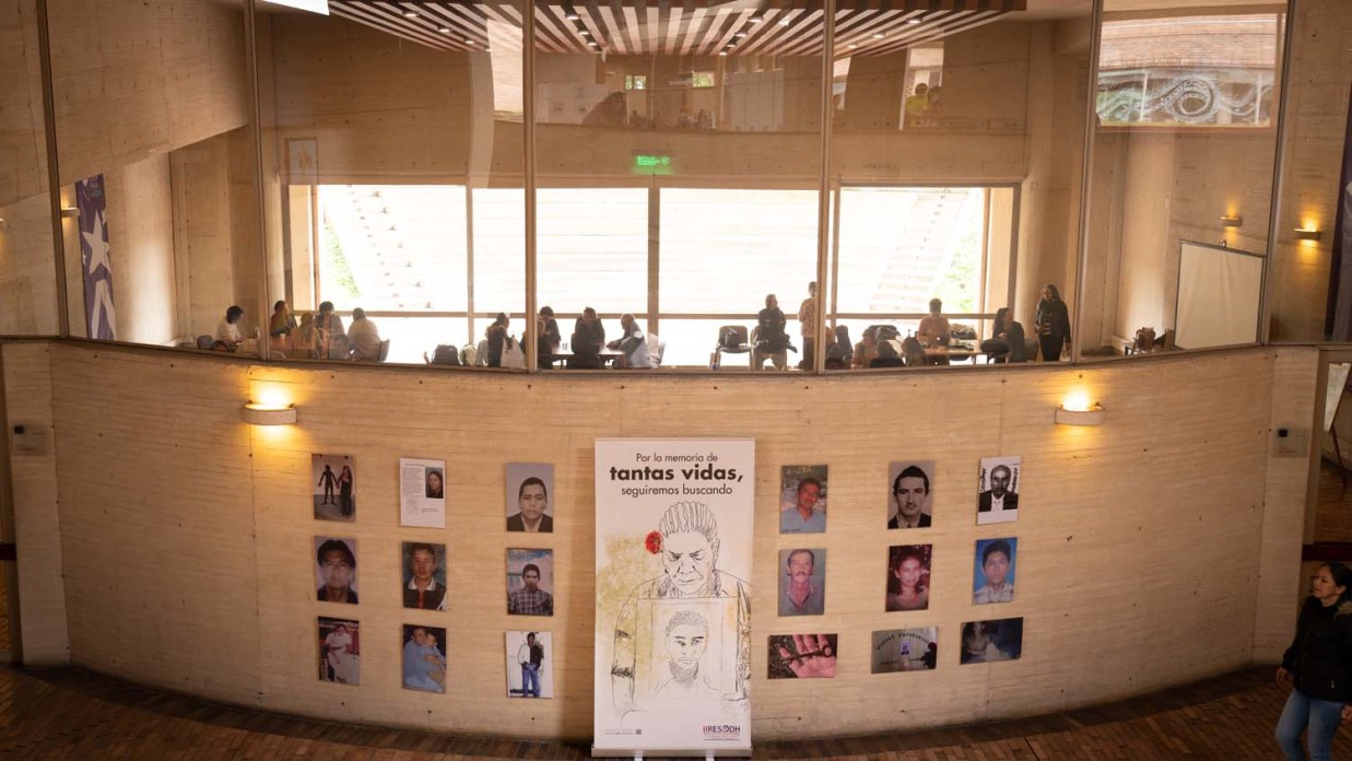 Outside view of a meeting room, with posters of people hung outside.