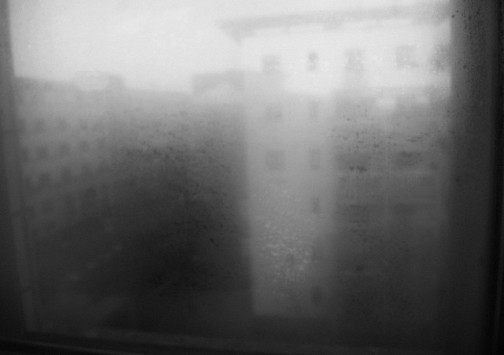 An artistic photograph of buildings seen through a foggy window.