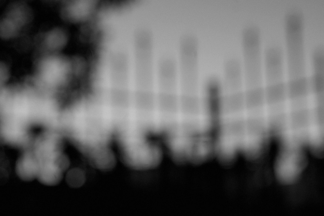 An artistic photograph of an out of focus wrought iron fence in black and white.