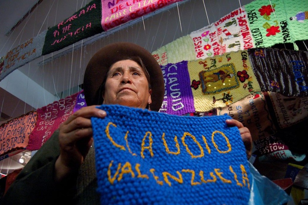 A woman holding a knitted scarf.