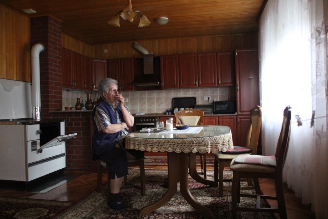 A woman sitting alone at a kitchen table.